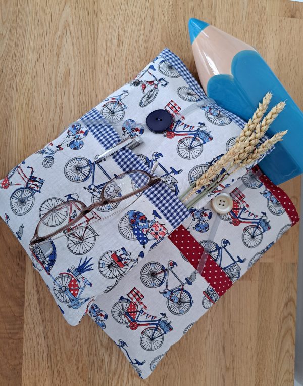 Protège livre en coton imprimé de vélos et bande rouge ou bleue. Une grande poche pour le livre et une petite pour ranger les accessoires (lunette crayon)