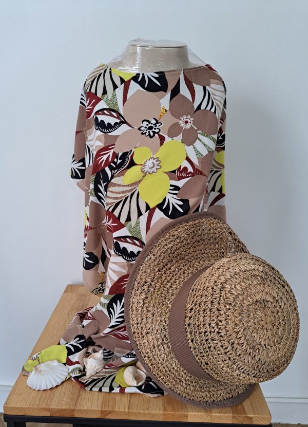 Vue de dos de la robe de plage Cynthia en viscose, accompagnée d’un chapeau de paille posé pour une ambiance estivale chic et naturelle.