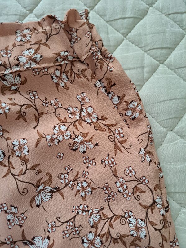 Short beige rosé à petites fleurs blanches. Vue détaillée sur poche