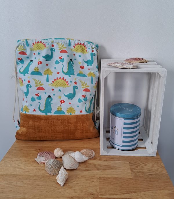 Sac ficelles vue de dos, motifs dinosaures, fond velours jaunes doré
