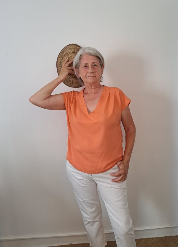 Top femme en bambou, couleur corail porté avec un pantacourt blanc