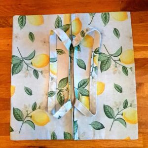 « Sac à tarte “Petit Citron” posé ouvert, motif citron, sur fond bois »