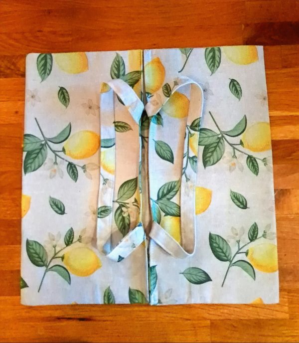 « Sac à tarte “Petit Citron” posé ouvert, motif citron, sur fond bois »