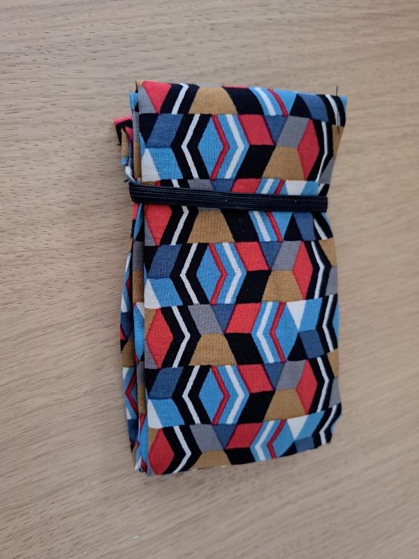 Sac de courses style Shupatto en viscose aux motifs géométriques colorés, posé à plat sur une table en bois.