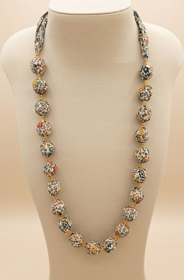 Collier Nomade en tissu Liberty, façonné autour de perles en bois brut pour une allure bohème et artisanale. Une pièce légère, colorée et unique, imaginée et confectionnée par Les Coutures de Miette